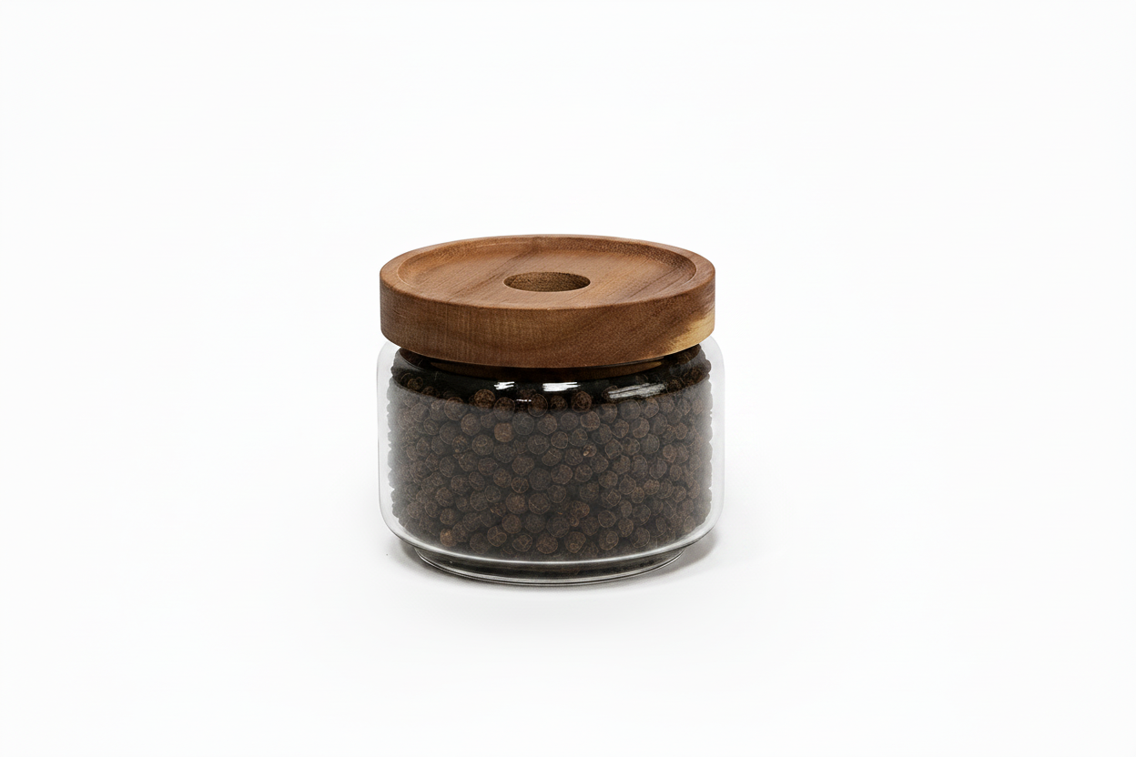 A clear glass jar filled with dark brown peppercorns, topped with a round wooden lid, shown on a white background with dimension lines indicating 90 mm width and 80 mm height.